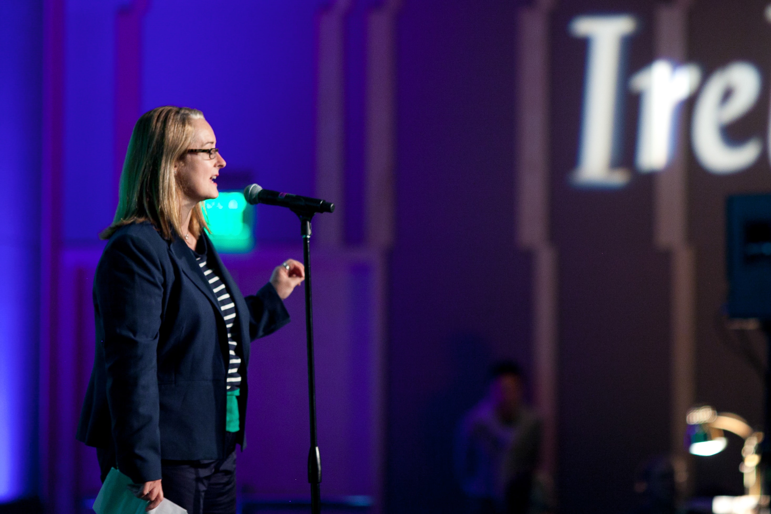 Woman Speaking at Microphone — Events photography by Spice & Ink
